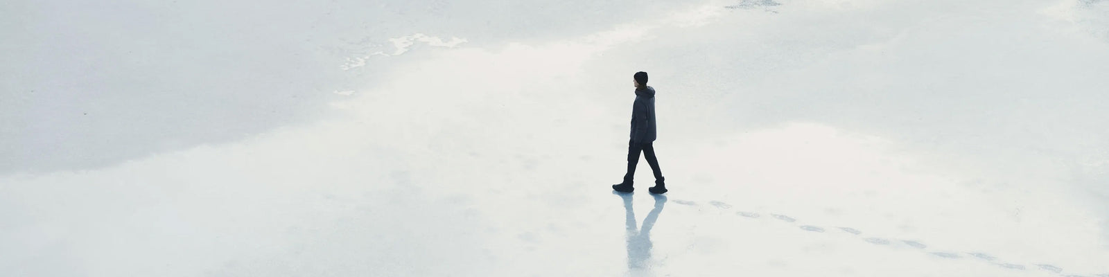 Houdini figure walking across snow-covered landscape in minimalist winter setting.