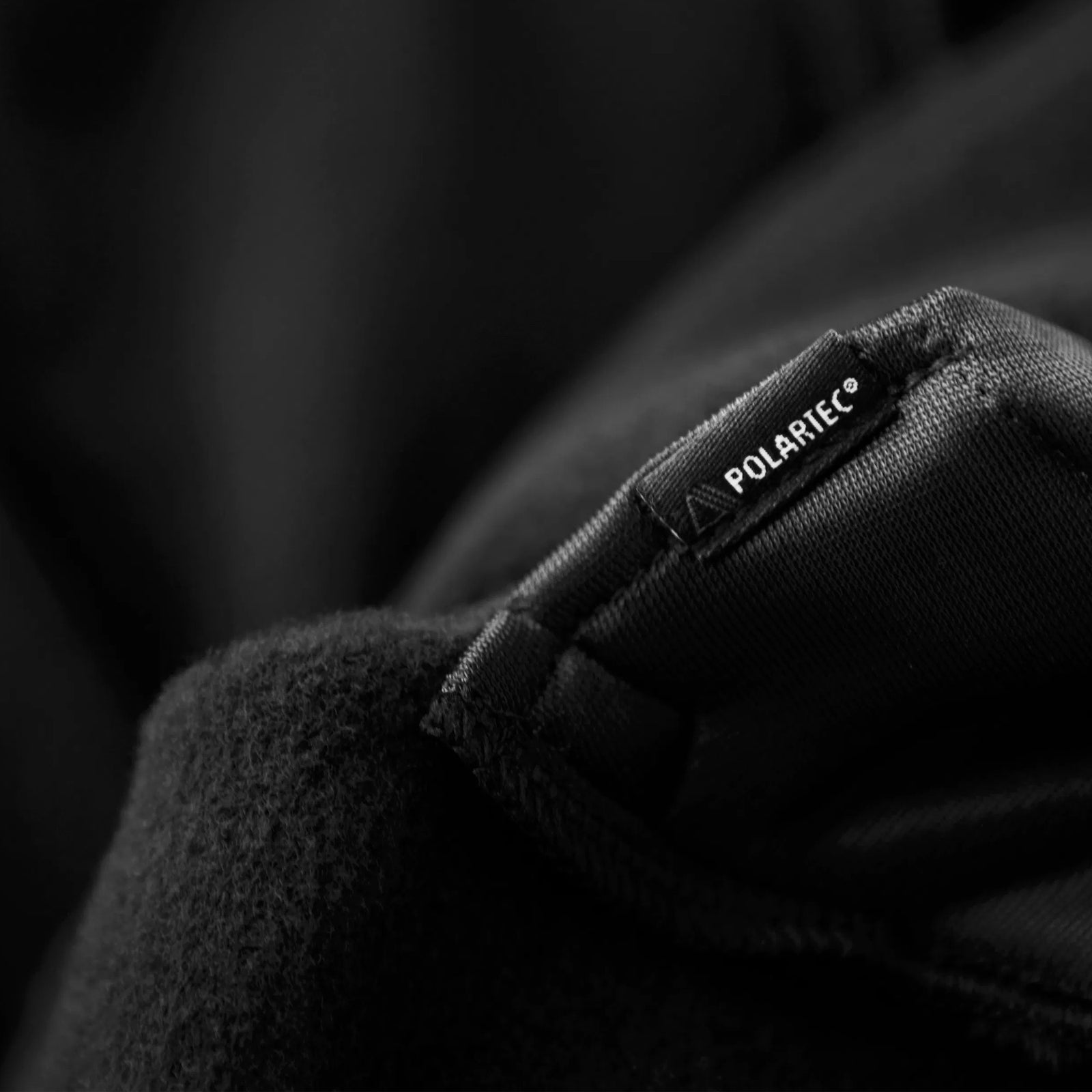 Close-up of Polartec branded fabric label on Houdini clothing material.